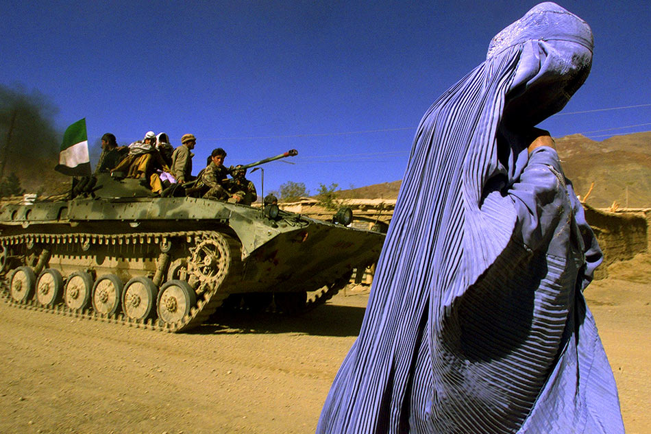 An Afghan woman wearing a traditional burqa walks on the side of a road in the outskirts of Jabal us Seraj, some 60 kms north of the Afghan capital Kabul in November 2001. Yannis Behrakis, Reuters/file