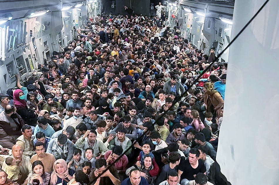 Evacuees crowd the interior of a US Air Force C-17 Globemaster III transport aircraft, carrying some 640 Afghans to Qatar from Kabul, Afghanistan August 15, 2021. Courtesy of Defense One/Handout via Reuters