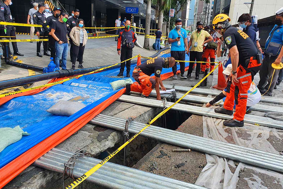 Local officials on Tuesday inspect the biggest of the cracks that appeared on Topaz Road in Pasig City. Courtesy of Barangay San Antonio, Pasig LGU