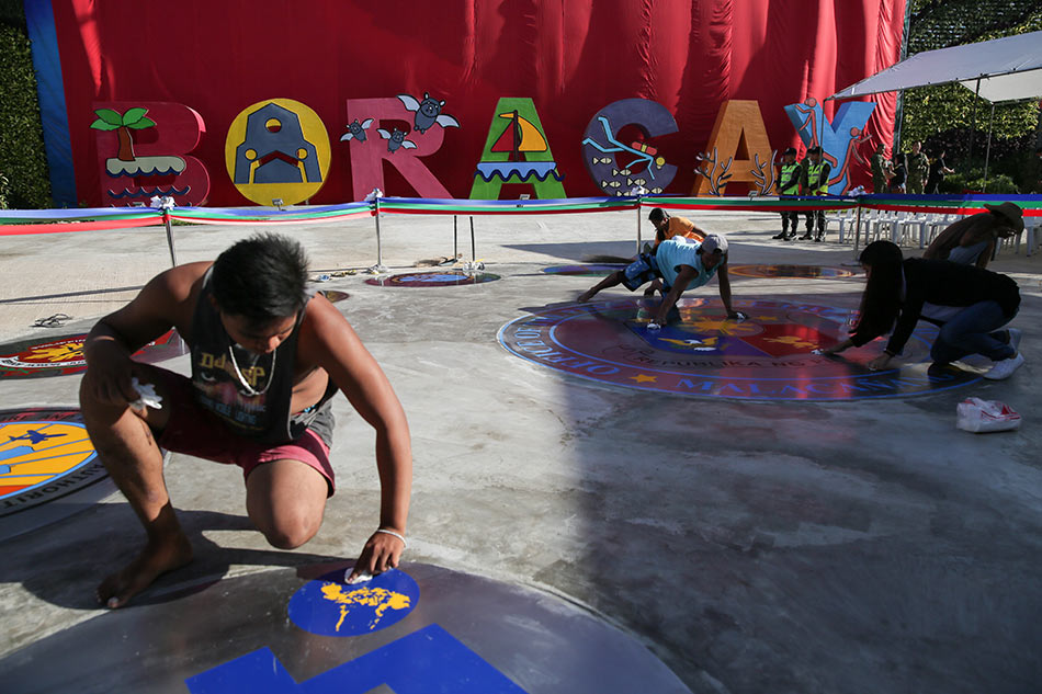 Workers put finishing touches on signs at the Cagban port before ceremonies formally reopening Boracay island on October 26, 2018 after a six-month closure to tourists. Fernando G. Sepe Jr., ABS-CBN News