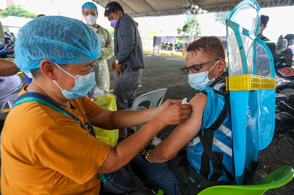 Health workers vaccinate residents in Quezon City on September 14, 2021. Charlie Villegas, OVP handout/file