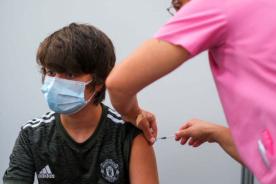 A boy receives his second dose of the Pfizer coronavirus disease (COVID-19) vaccine in Seixal, Portugal on September 11, 2021. Pedro Nunes, Reuters