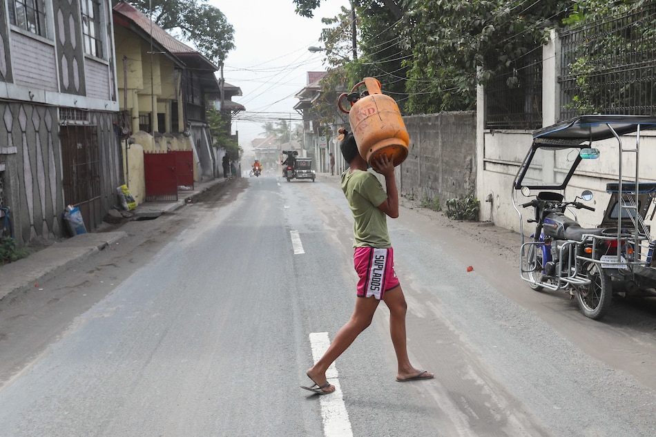 A man carries an LPG tank George Calvelo, ABS-CBN News file photo