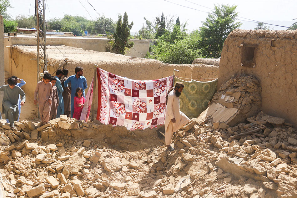 Residents gather near a damaged Pakistan quake via Reuters