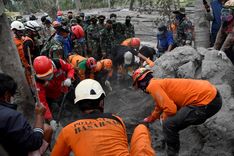  Indonesian rescue officers find a victim in an area affected by the eruption of Mount Semeru volcano in Sumber Wuluh, Lumajang, East Java Province, Indonesia December 6, 2021, in this photo taken by Antara Foto/Zabur Karuru/via Reuters