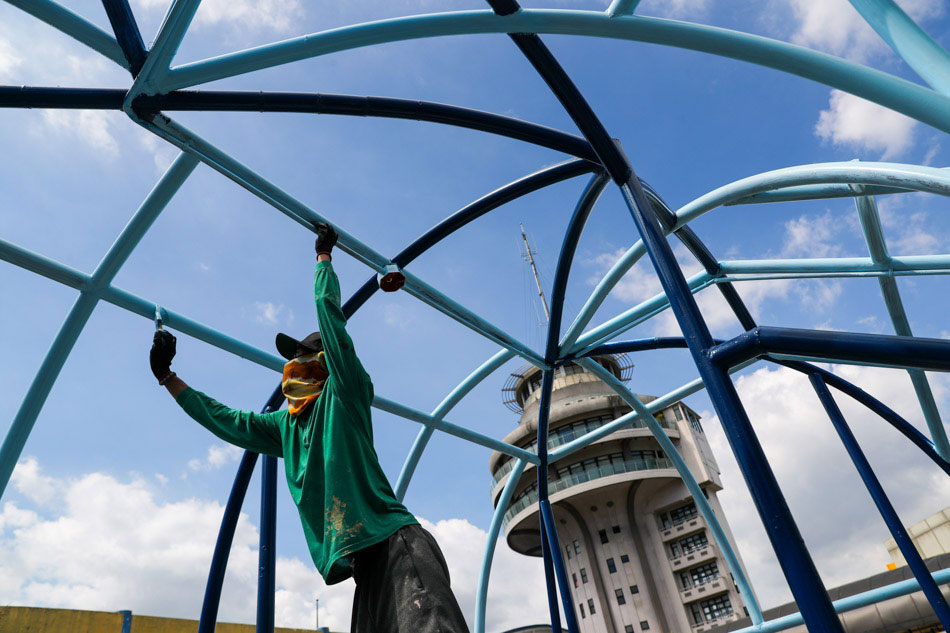 A worker paints a portion of the Pasig city hall elevated walkway on March 2, 2021. Jonathan Cellona, ABS-CBN News/file
