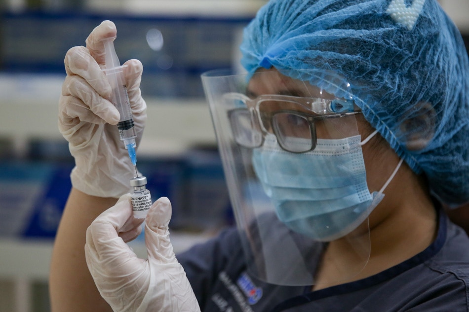 A health worker prepares the Pfizer COVID-19 vaccine during its first rollout inside the Makati Medical Center on May 12, 2021. George Calvelo, ABS-CBN News/File