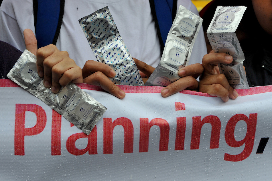 Members of the Reproductive Health Advocacy Network rally near the Malacañang Palace in support of then Philippine President Benigno Aquino