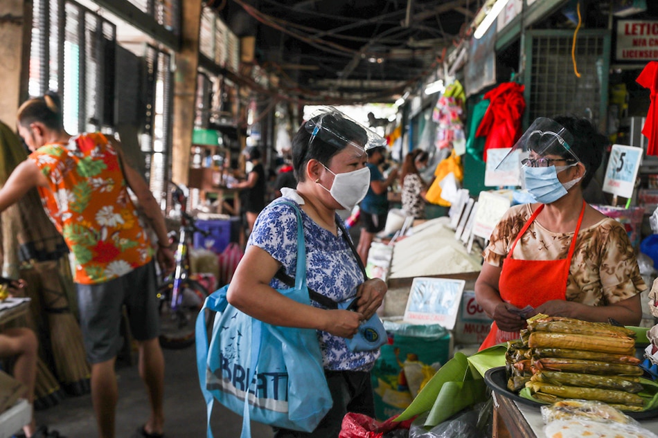 People wearing face masks and face shields as a precaution against COVID-19 purchase fruits at the Kamuning Market on May 18, 2021. Jonathan Cellona, ABS-CBN News