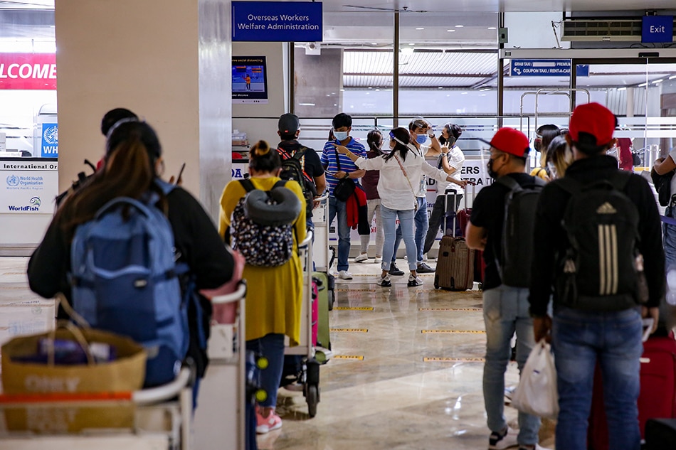 Overseas Filipino Workers are assisted by members of the Overseas Workers Welfare Administration and the Philippine Coast Guard at the arrival lobby of the Ninoy Aquino International Airport Terminal 1 in Pasay City on June 3, 2021. George Calvelo, ABS-CBN News/File