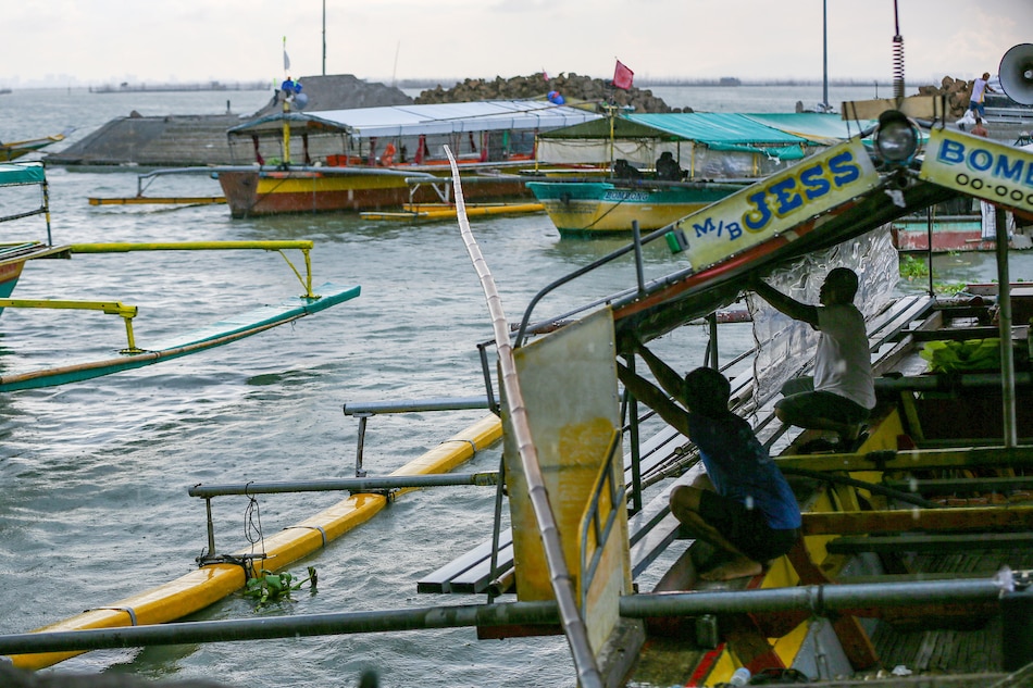 Boatmen attend to their vessels as people take passenger ferries from the Binangonan Fish Port in Rizal province on June 9, 2021 during the onset of the country's rainy season. Jonathan Cellona, ABS-CBN News/File