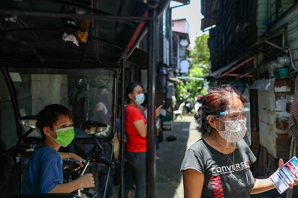 Residents wait as authorities distribute quarantine passes in Barangay Batis, San Juan.