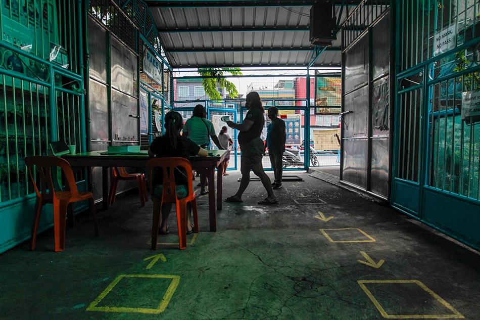 Parents submit the enrollment form of their children in a drop box at the Rosauro Almario Elementary School in Tondo, Manila