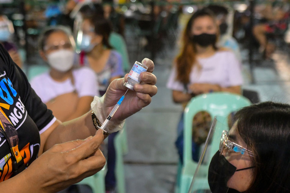 Caloocan City residents receive their COVID-19 vaccine dose at the Notre Dame of Greater Manila vaccination site on August 16, 2021. Mark Demayo, ABS-CBN News