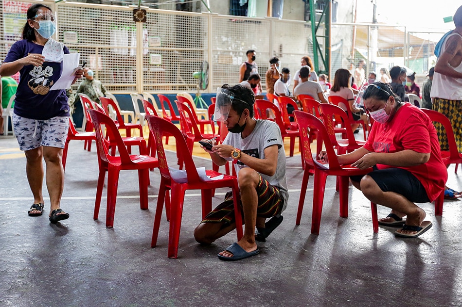 Residents fill out their barangay certification prior to receiving the government’s cash aid in Barangay 48, Tondo, Manila on Aug. 17, 2021. George Calvelo, ABS-CBN News 