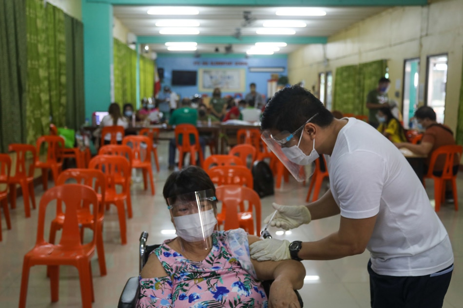 Health workers and medical frontliners attend to residents at a vaccination site at the Sta. Ana Elementary School in Manila on Aug. 13, 2021. Jonathan Cellona, ABS-CBN News