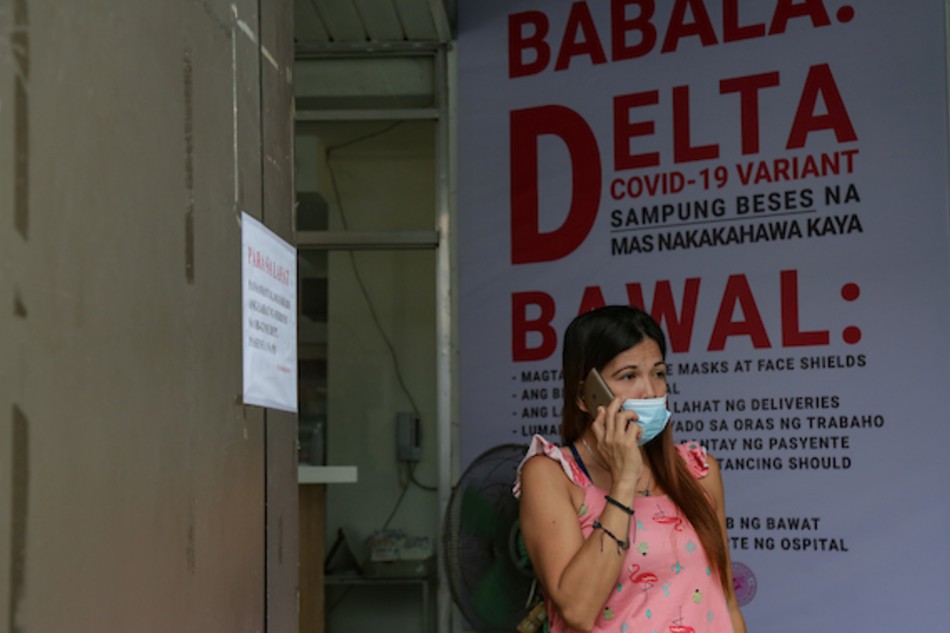 A woman waits outside the Pasay City General Hospital on August 21, 2021. The hospital temporarily closed its Obstetrics and Gynecology (OB-GYN) services until August 26 to address the significant number of COVID-19 cases among their medical officers. George Calvelo, ABS-CBN News