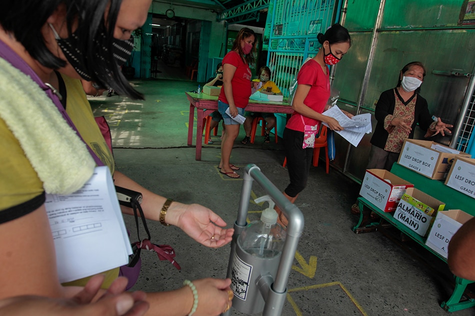 Parents submit the Learner Enrollment Survey Form of their children in a drop box at the Rosauro Almario Elementary School in Tondo, Manila on Tuesday. 