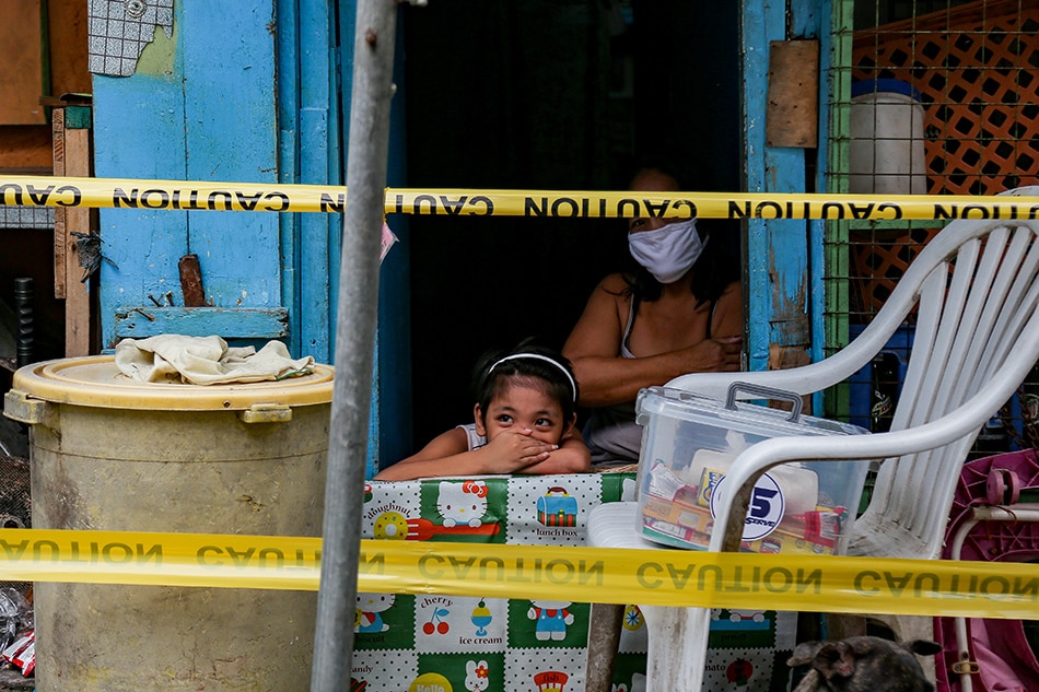 A child covers her face while in her family home in Barangay UP Campus, Quezon City on the first day of the reimposition of enhanced community quarantine on Aug. 6, 2021. George Calvelo, ABS-CBN News/File