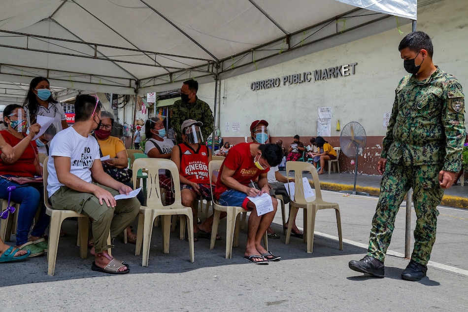 People wait in line as the Manila Health Department inoculate market workers and vendors at the Blumentritt Market in Sta. Cruz, Manila on August 28, 2021. According to officials, around 1,000 individuals are targeted to be vaccinated with Sinovac’s COVID-19 vaccine. 