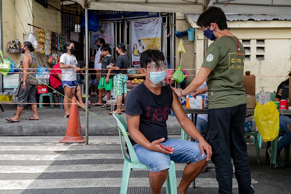 Members of the Manila Health Department inoculate market workers and vendors at the Blumentritt Market in Sta. Cruz, Manila on August 28, 2021. 