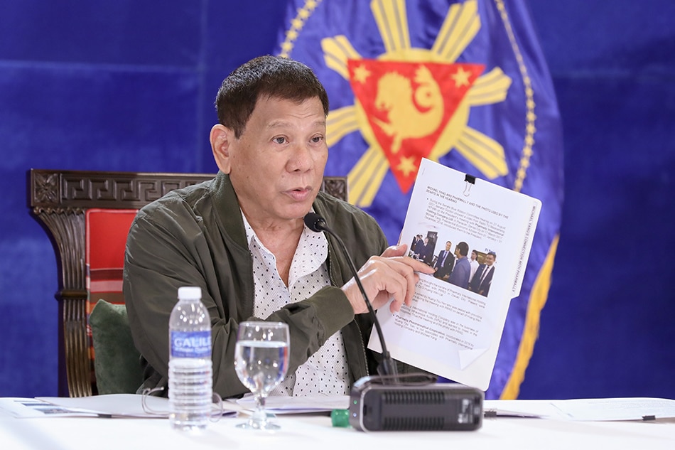 President Rodrigo Duterte delivers a national address at the Arcadia Active Lifestyle Center in Matina, Davao City on Aug. 30, 2021, He shows a document with a photo of his former economic adviser Michael Yang, who allegedly introduced him to owners of Pharmally, a firm that bagged pandemic contracts. Richard Madelo, Presidential Photo/File    