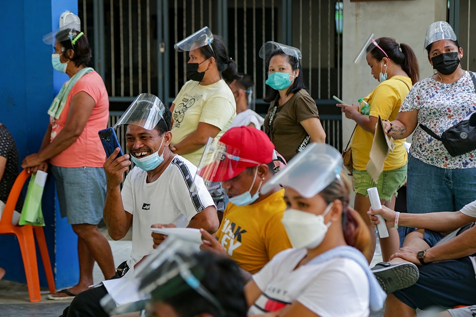 Residents line up to receive government’s cash aid at the Jose Abad Santos High School in Manila on August 13, 2021. The distribution of cash assistance started last Wednesday to aid Filipinos who are gravely affected by the 2-week lockdown.