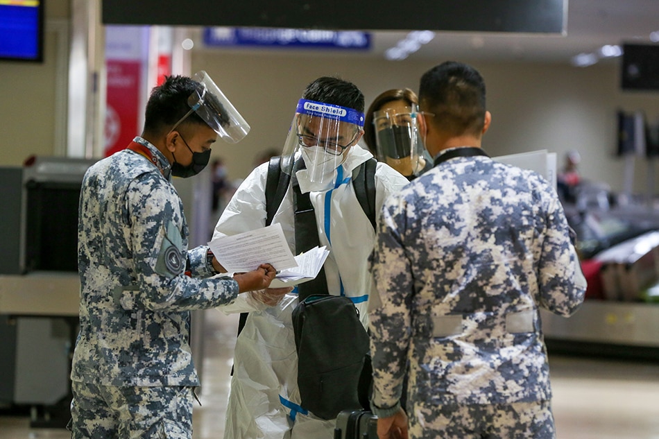 Philippine Coast Guard personnel ask travelers for pertinent documents and information as they arrive at the Ninoy Aquino International Airport (NAIA)Terminal 1 in Parañaque City on July 01, 2021. Jonathan Cellona, ABS-CBN News