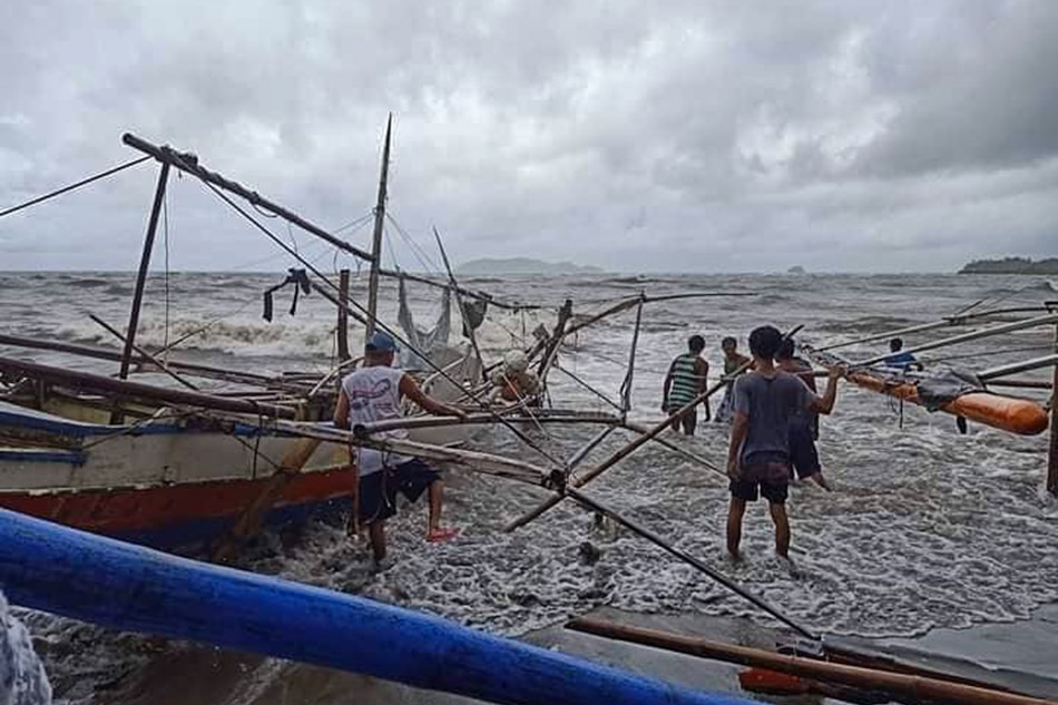 Fishermen secure their outrigger boats from rough seas in Barangay Punta Cogon, Roxas City during the onslaught of Typhoon Jolina. The city government evacuated residents along the shores as Jolina battered Capiz, according to weather bureau PAGASA.
