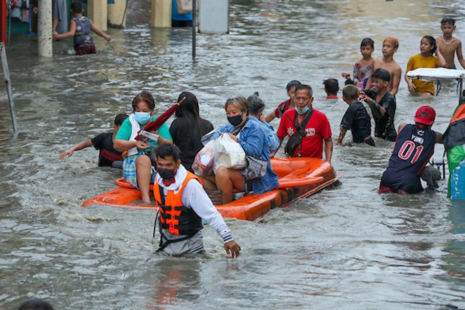 Commuters traverse the flooded portion of Zapote Alabang Junction in Las Pinas City on September 8, 2021 due to rains brought by severe Tropical Storm Jolina. 