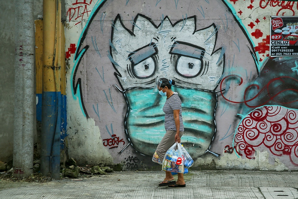 A person passes in front of a mural on 5th Avenue in Caloocan City on Aug. 30, 2021. Jonathan Cellona, ABS-CBN News/File