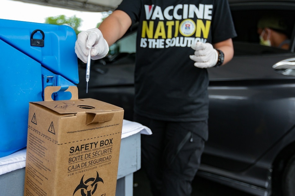 Health workers administer Pfizer’s COVID19 vaccine at the drive thru vaccination site located at the Quirino grandstand in Manila on Sept. 11, 2021. George Calvelo, ABS-CBN News/File