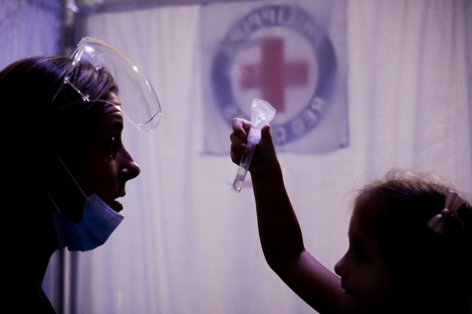 A mother guides her child during a saliva test inside a COVID-19 saliva testing center at the Philippine Red Cross headquarters in Mandaluyong City on Feb. 4, 2021. Basilio H. Sepe, ABS-CBN News/File 