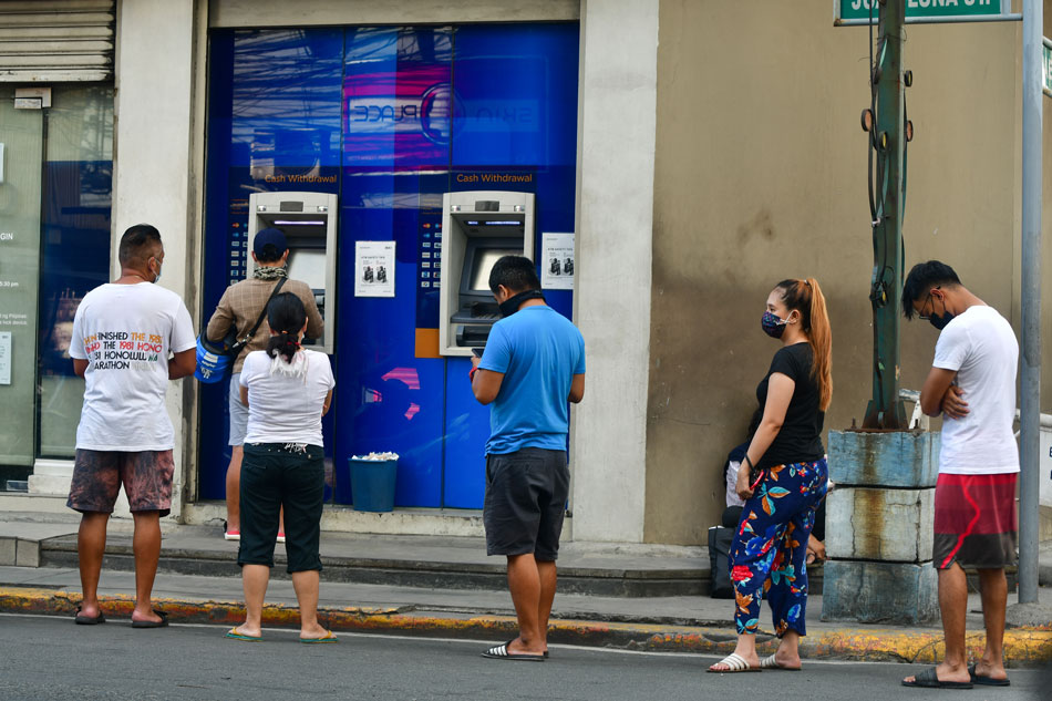 Customers line up at a bank's ATM in Manila on March 30, 2021. Mark Demayo, ABS-CBN News/FILE