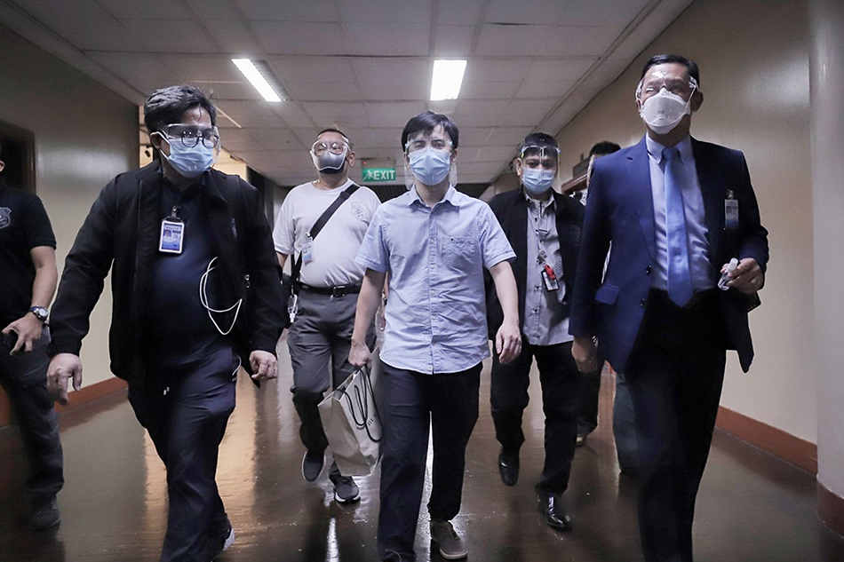 Members of the Office of the Sergeant-At-Arms escort Pharmally Pharmaceuticals Corporation Executive Linconn Ong inside the Senate building Tuesday, Sept. 21, 2021. Ong was cited in contempt and ordered to be arrested by the Blue Ribbon Committee for evading questions during a hybrid inquiry on the 2020 Commission on Audit report and other issues related to budget utilization of the health department, especially expenditures related to the COVID-19 fight.