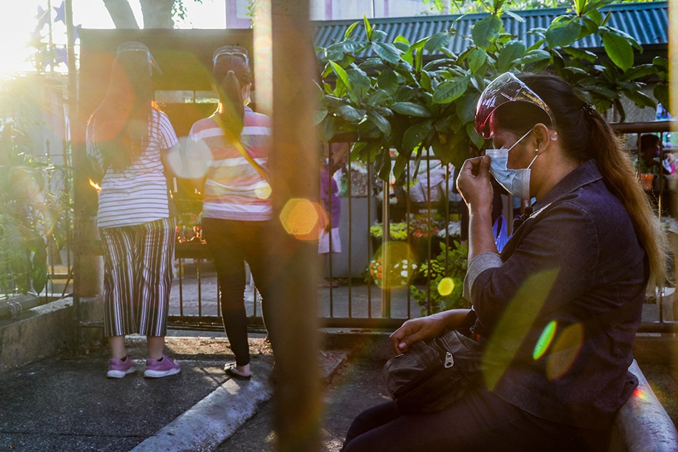 People wearing face masks and faceshields pray at an outdoor altar at the San Felipe Neri Parish Church in Mandaluyong on September 24, 2021. 