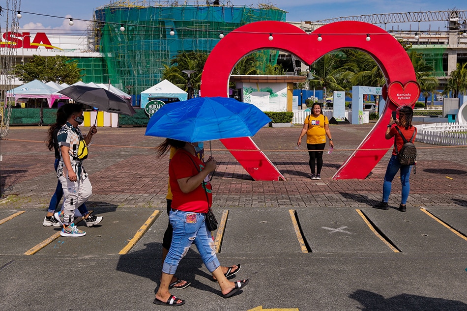 People stroll along the Mall of Asia by the bay on Sunday, Oct. 10, 2021. George Calvelo, ABS-CBN News