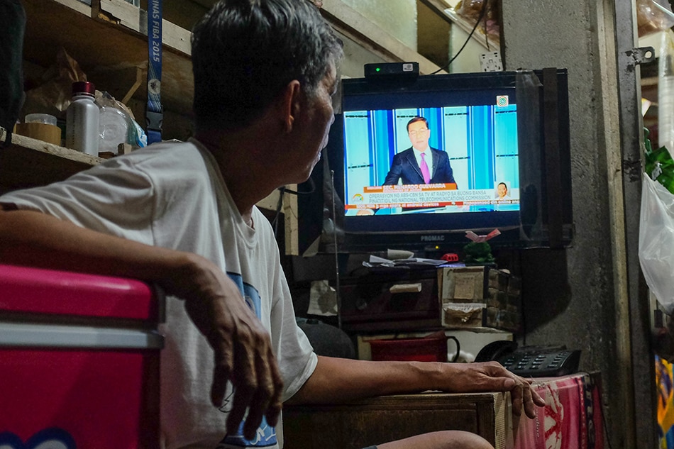 A store-owner watches the final airing of TV Patrol moments before ABS-CBN signed off on May 5, 2020. George Calvelo, ABS-CBN News/File