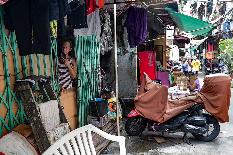 A man spends time by the door of his house at a neighborhood in Tondo, Manila on August 12, 2021. George Calvelo, ABS-CBN News