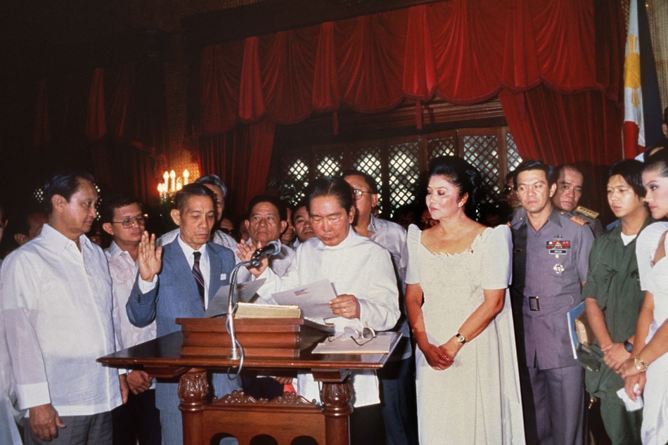 Ferdinand Marcos (1917-89) Philippines statesman and president (1965-86) takes oath 24 February 1986 in Manila while his wife Imelda looks on. Marcos' regime as president was marked by increasing repression, misuse of foreign financial aid, and political murders (notably, the assassination of Benigno Aquino in 1983). He declared martial law in 1972, but was overthrown in 1986 by a popular front led by Corazon Aquino. AFP