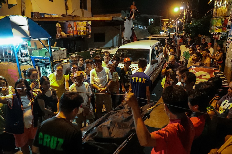 Coroners pass through crowds as they carry 1 of the 3 bodies of drug pushers killed in a buy bust operation in Pandacan Manila on July 21, 2016. Jonathan Cellona, ABS-CBN News/File