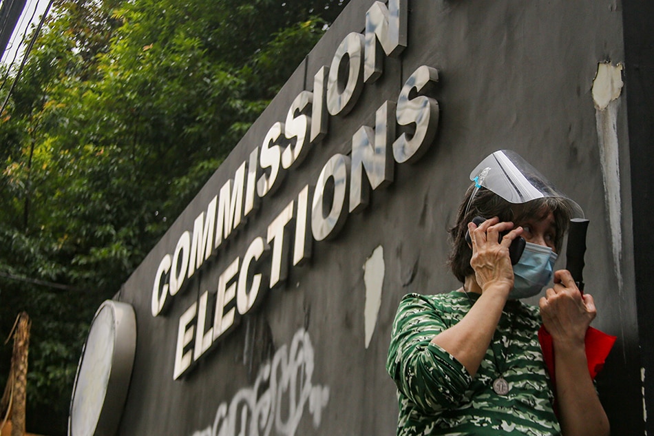 A woman uses her phone outside the Commission on Elections (Comelec) building in Quezon City on October 14, 2021. Jonathan Cellona, ABS-CBN News/File