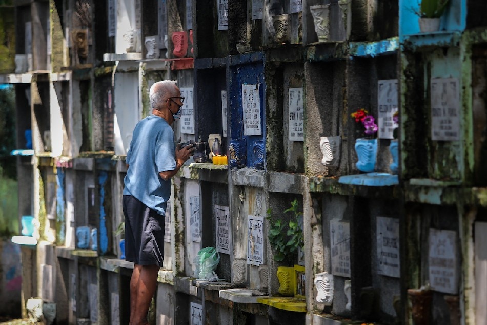A man visits and cleans the tomb of a departed loved one at the Manila South Cemetery in Makati City on Sunday, ahead of the observance of All Souls Day on Nov. 2, 2021. Stringer