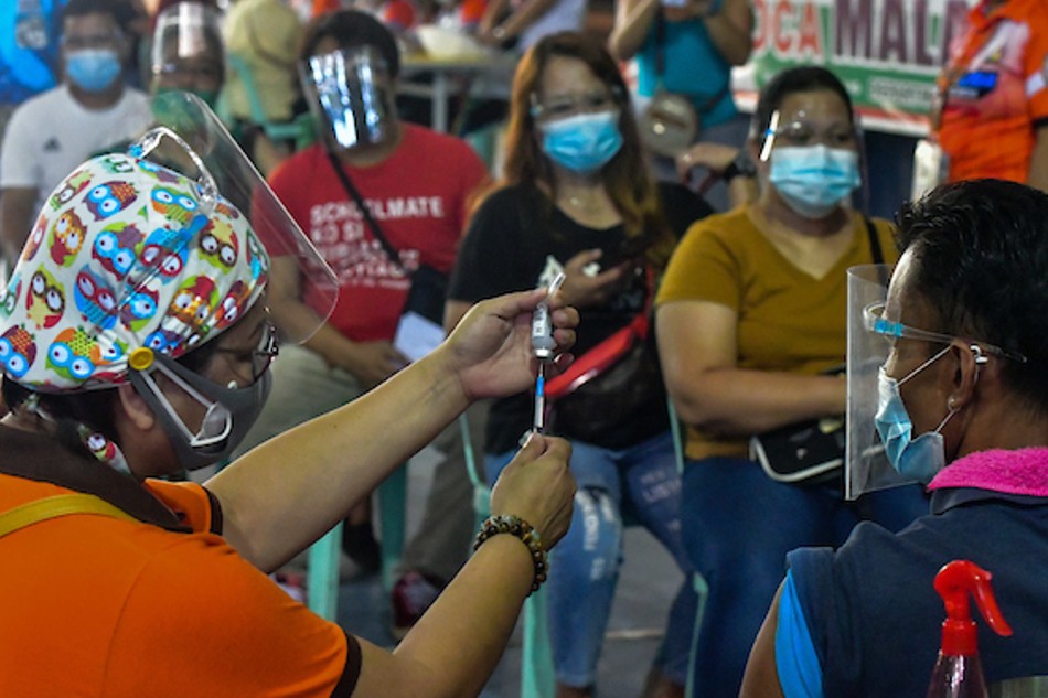 Caloocan City residents booked online receive their dose of a COVID-19 vaccine at the Notre Dame of Greater Manila vaccination site on August 16, 2021. Mark Demayo, ABS-CBN News