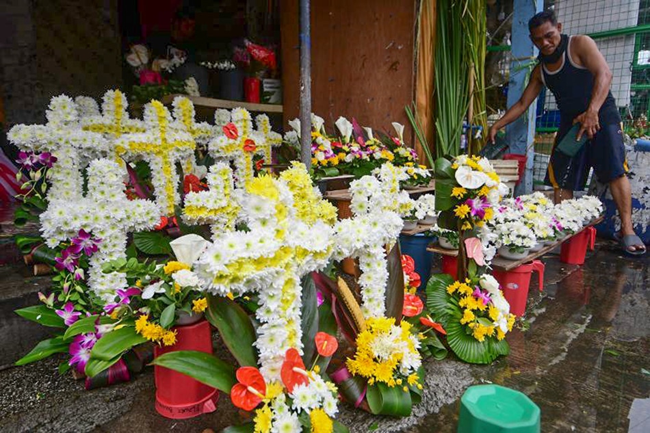 Nagbebenta ng bulaklak ang isang vendor sa Dangwa Flower Market sa Maynila kasabay ng pagdami ng mga bumibisita sa mga sementeryo bago mag-Undas. Isasara ang mga sementeryo mula Oktubre 29 hanggang Nobyembre 3 dahil sa banta ng pandemya. Mark Demayo, ABS-CBN News