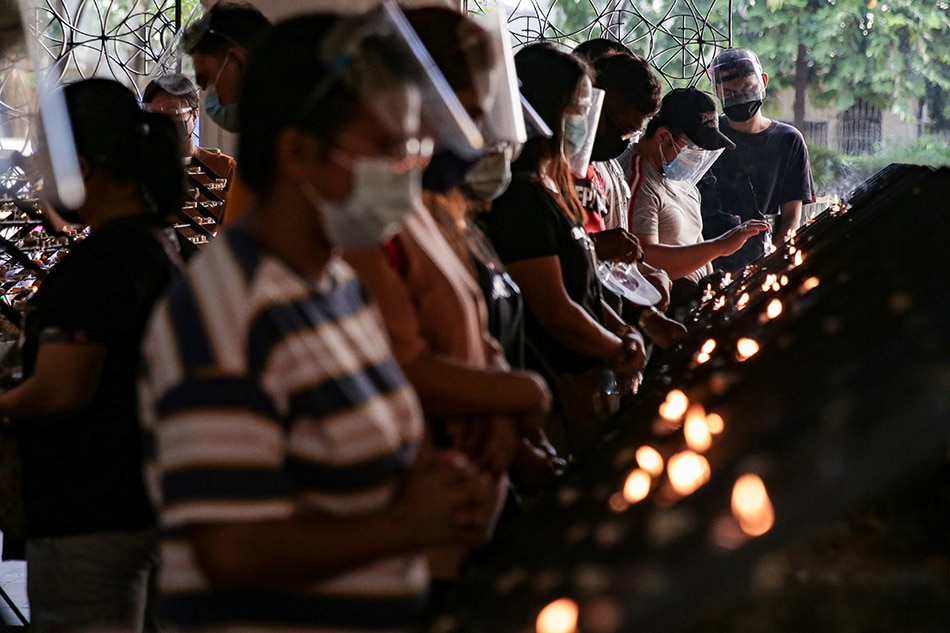 Filipino Catholics light candles as they visit the National Shrine of Our Mother of Perpetual Help or Baclaran Church for its first Wednesday mass on Nov. 3, 2021. The church allows 30% indoor capacity for fully vaccinated people and 50% outdoor capacity. George Calvelo, ABS-CBN News