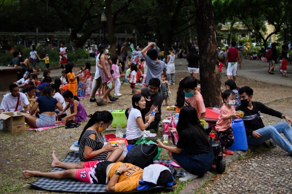 Parents and children relax at a public park, as the country's capital region loosens coronavirus disease (COVID-19) restrictions, in Quezon City, Metro Manila, Philippines, November 2, 2021. Picture taken November 2, 2021. Lisa Marie David, Reuters