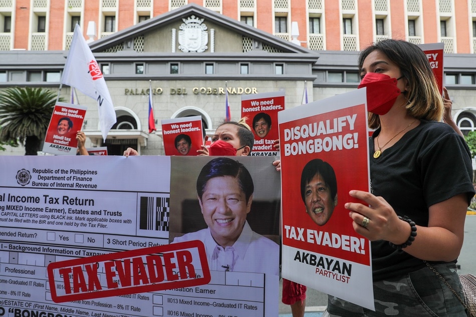 Members of Akbayan Partylist hold a protest action outside the Commission on Election headquarters on November 4, 2021, calling for the disqualification of presidential candidate Ferdinand 
