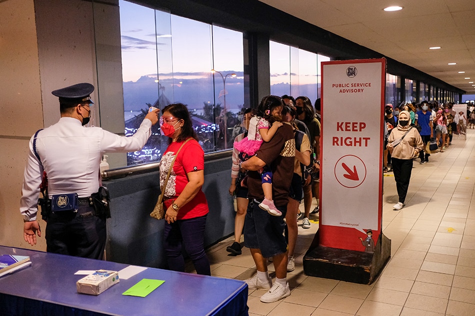 Nakapila ang ilang pamilya sa labas ng isang mall sa Pasay City noong Nobyembre 6, 2021, ang unang weekend matapos payagan ang mga bata sa mga pasyalan sa ilalim ng Alert Level 2. George Calvelo, ABS-CBN News