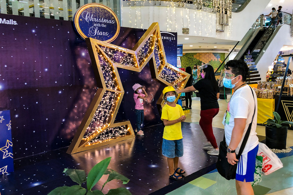 People take pictures with the Christmas installations at the V-Mall in San Juan City on November 6, 2021. Several Filipinos went out on the first weekend since restrictions were eased down to alert level 2, allowing all ages inside malls and public places. George Calvelo, ABS-CBN News